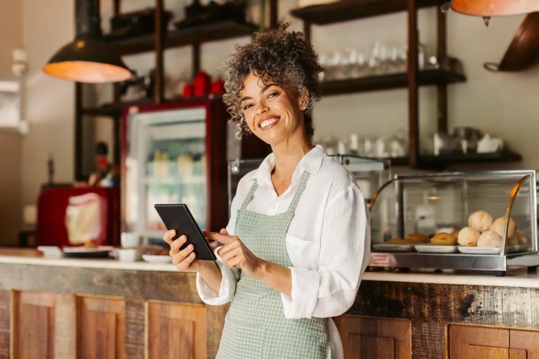 A restaurant owner with a smile, holding a tablet